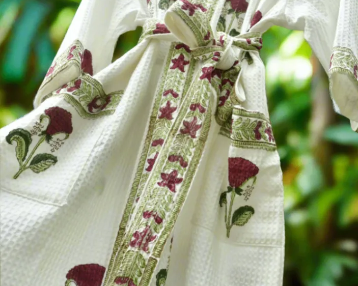 White robe with floral patterns on a blurred green background