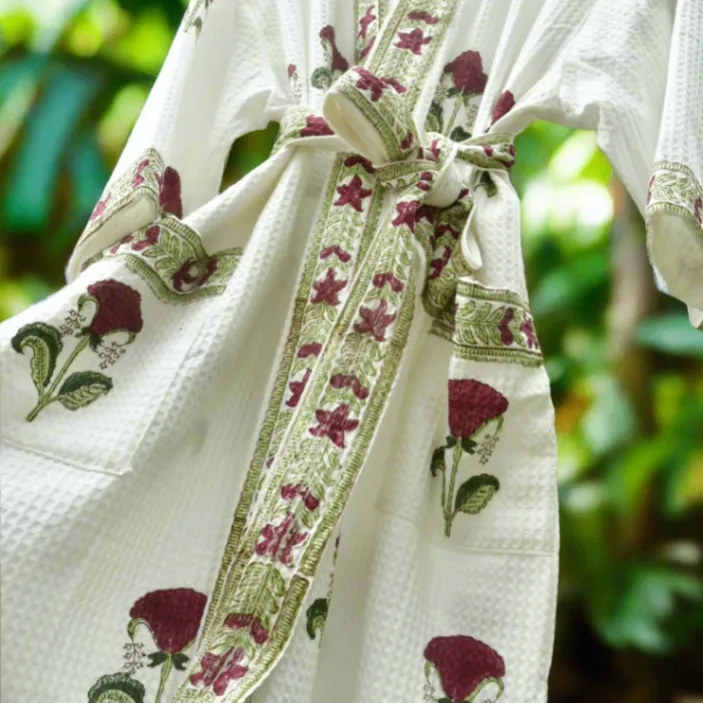 White robe with floral patterns on a blurred green background