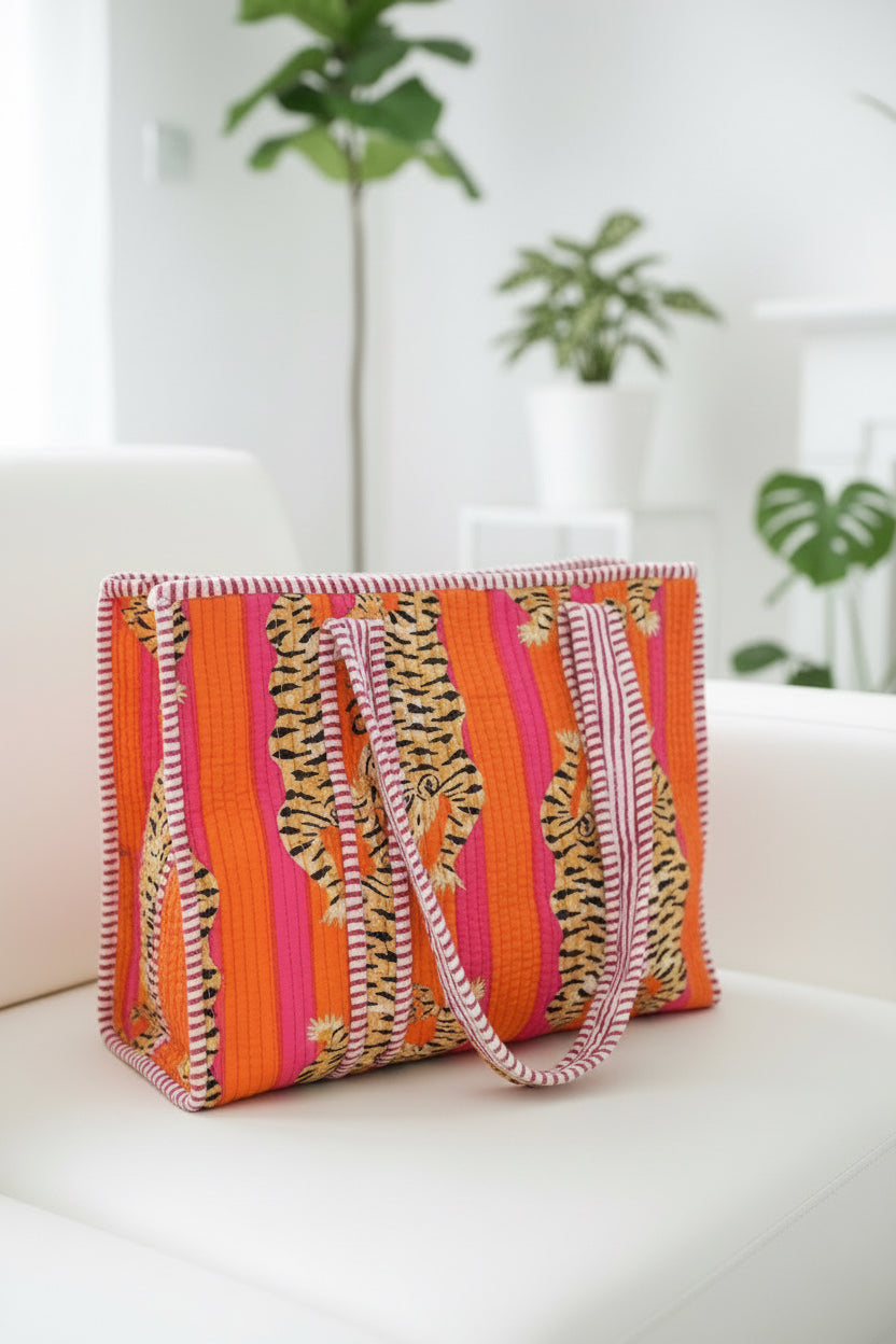 Colorful striped pink mini tote bag on a white surface with plants in the background