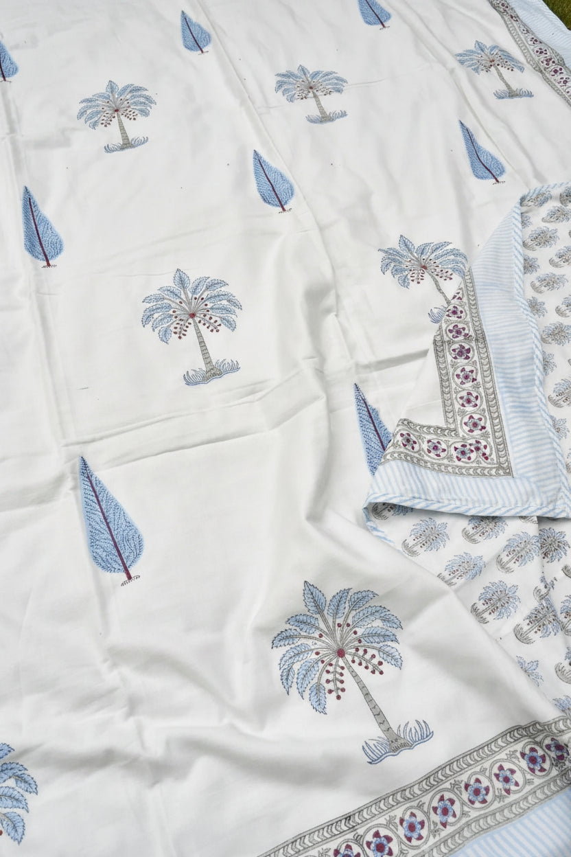 White fabric with blue palm tree patterns and decorative borders