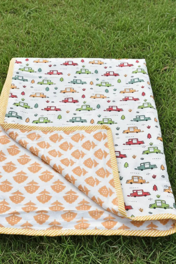 Baby blanket with car pattern on grass