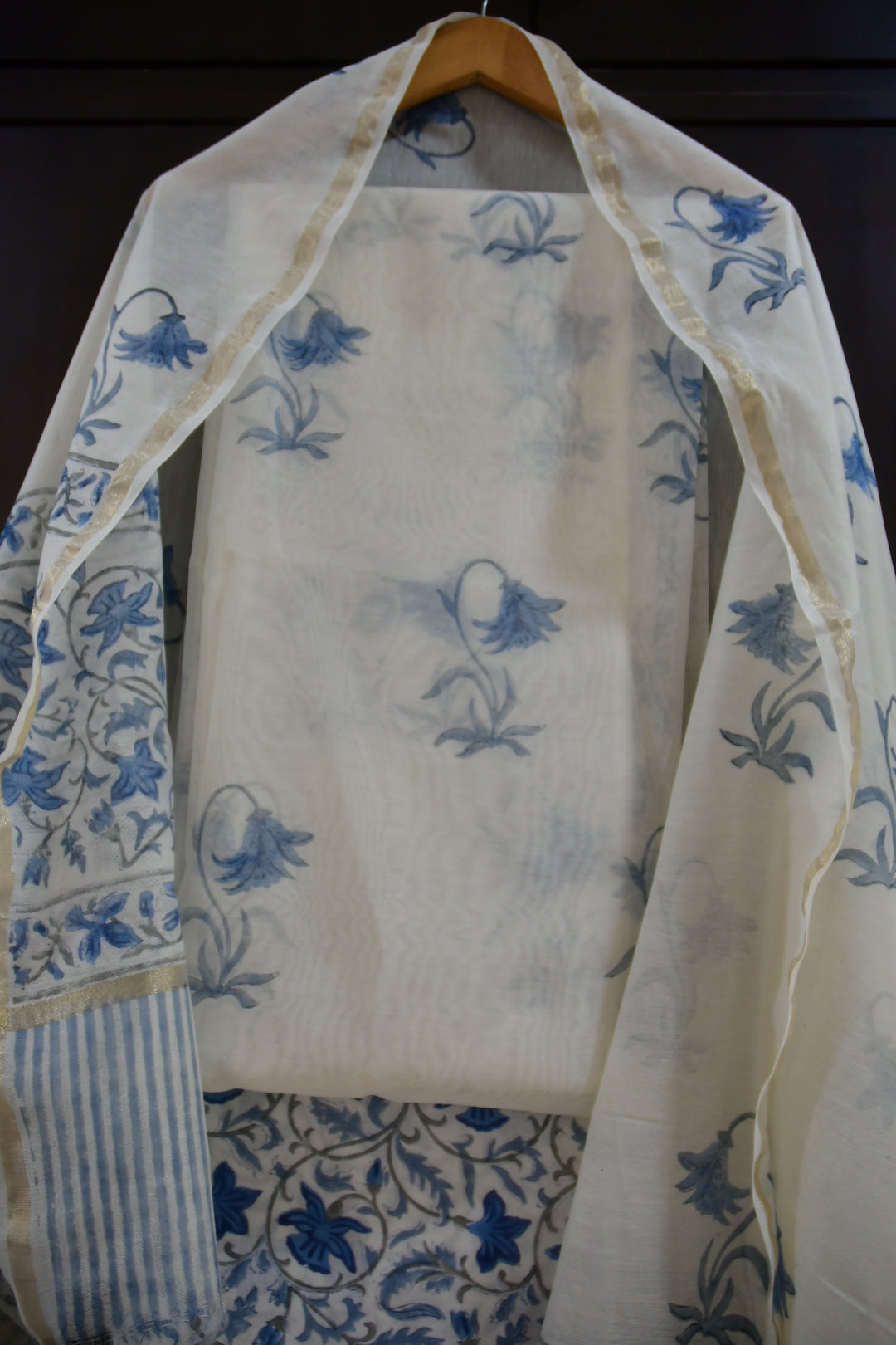 White fabric with blue floral patterns on a dark background