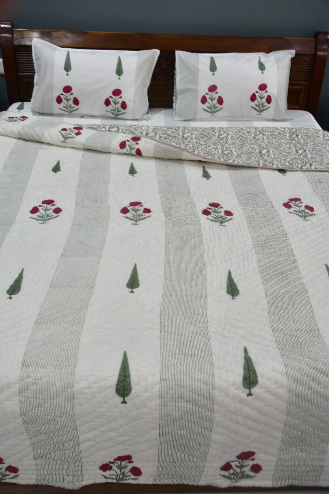 Bed with floral and striped patterned bedding