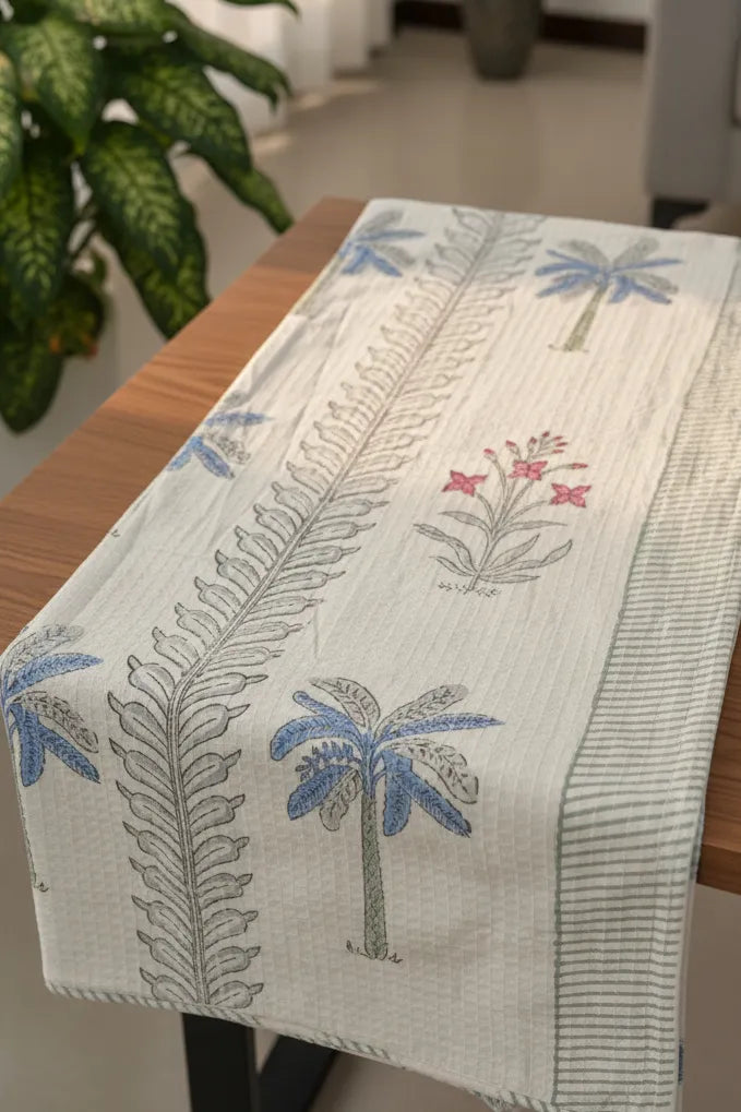 Table runner with palm tree and fern design on a wooden table