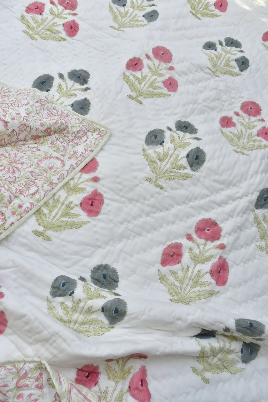 Floral quilt with pink and gray flowers on a white background