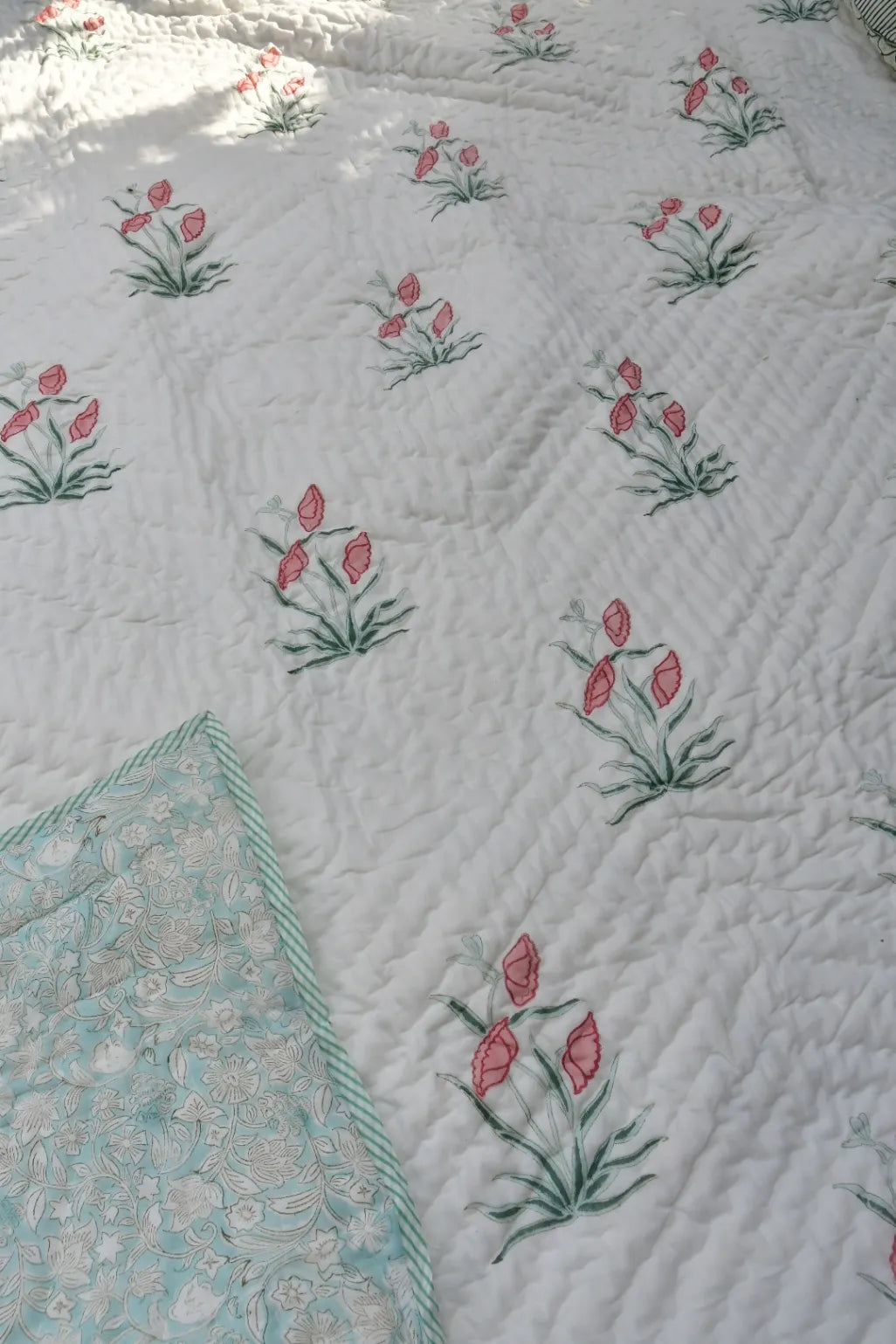 Floral patterned fabric with pink flowers and green leaves on a white background