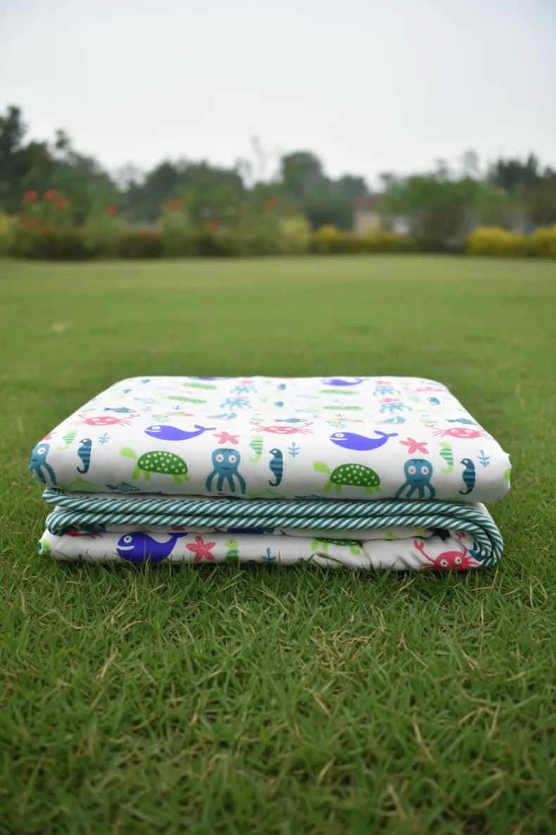 Stack of colorful children's dohar & blanket on grass