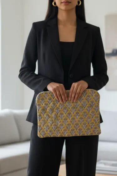 Woman holding a patterned laptop sleeve bag in a living room setting