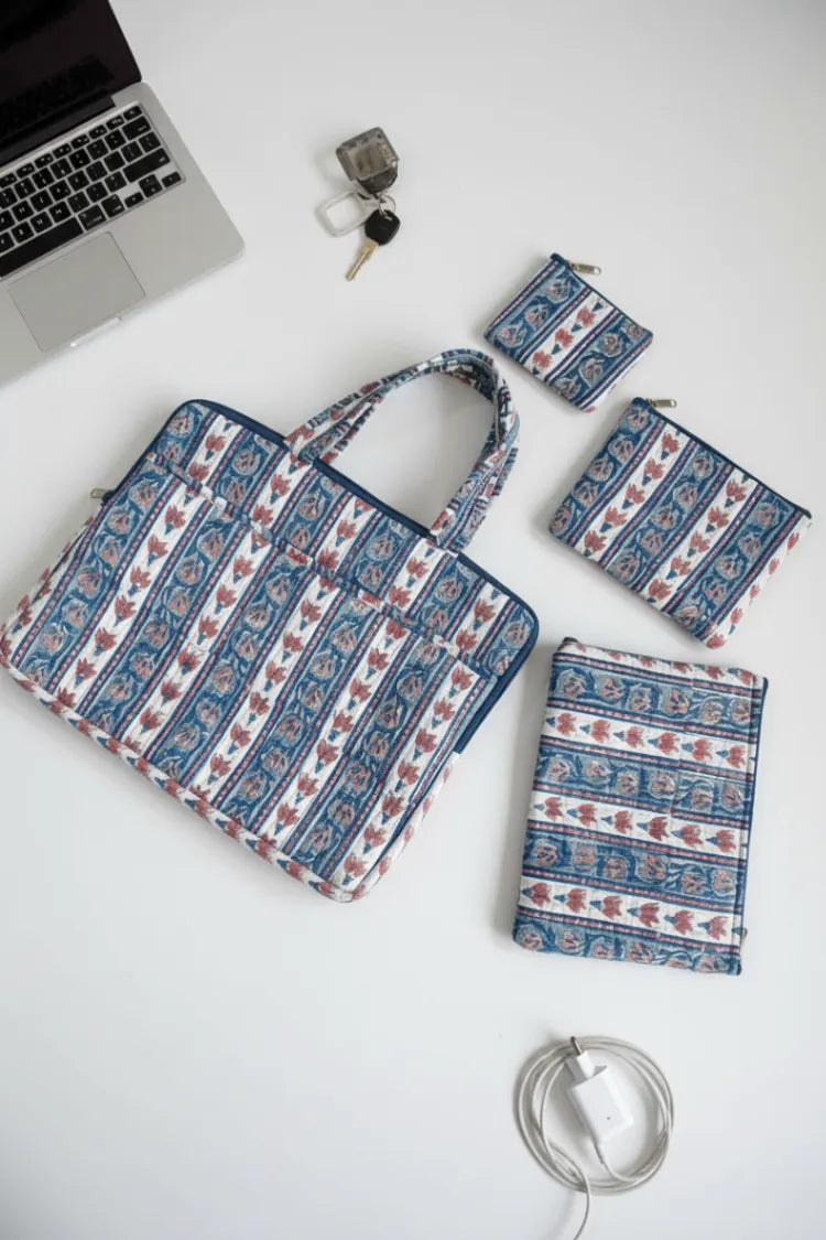 Set of patterned bags and pouches on a white surface with a laptop and keys.