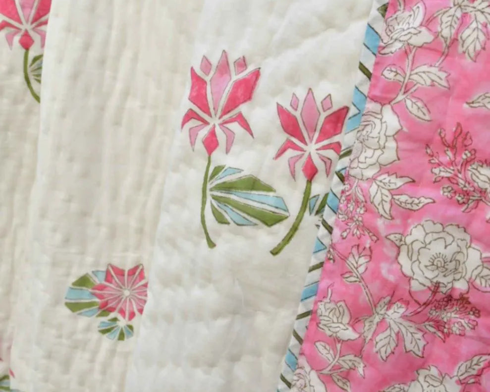 Close-up of a floral quilt with pink and white patterns