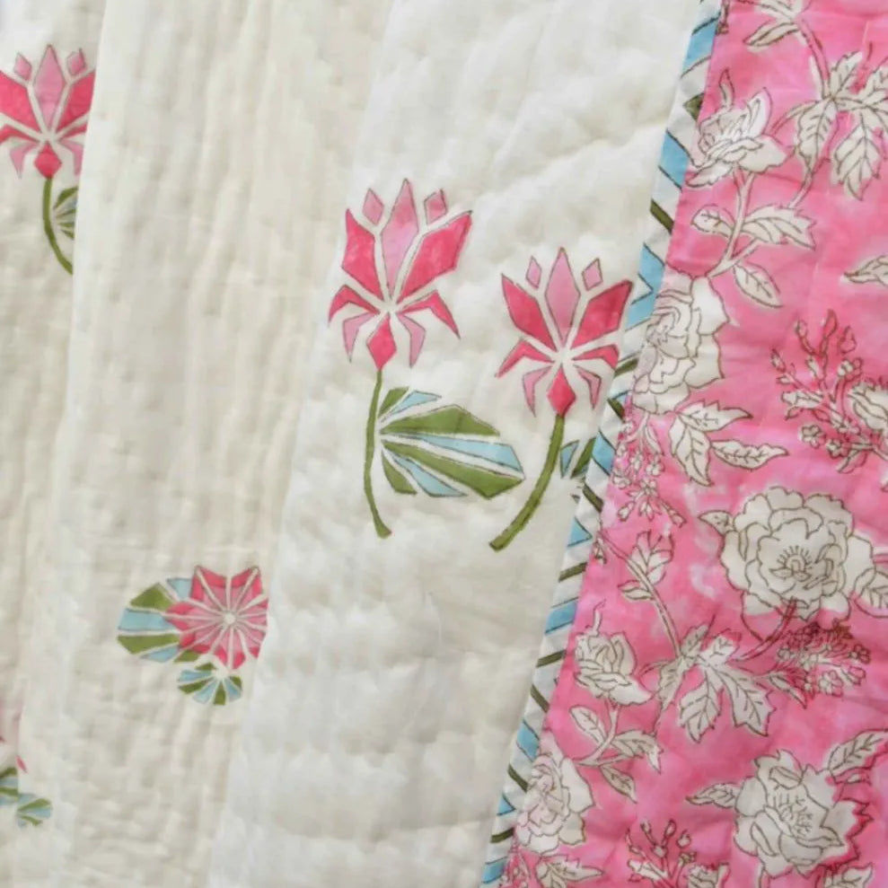 Close-up of a floral quilt with pink and white patterns