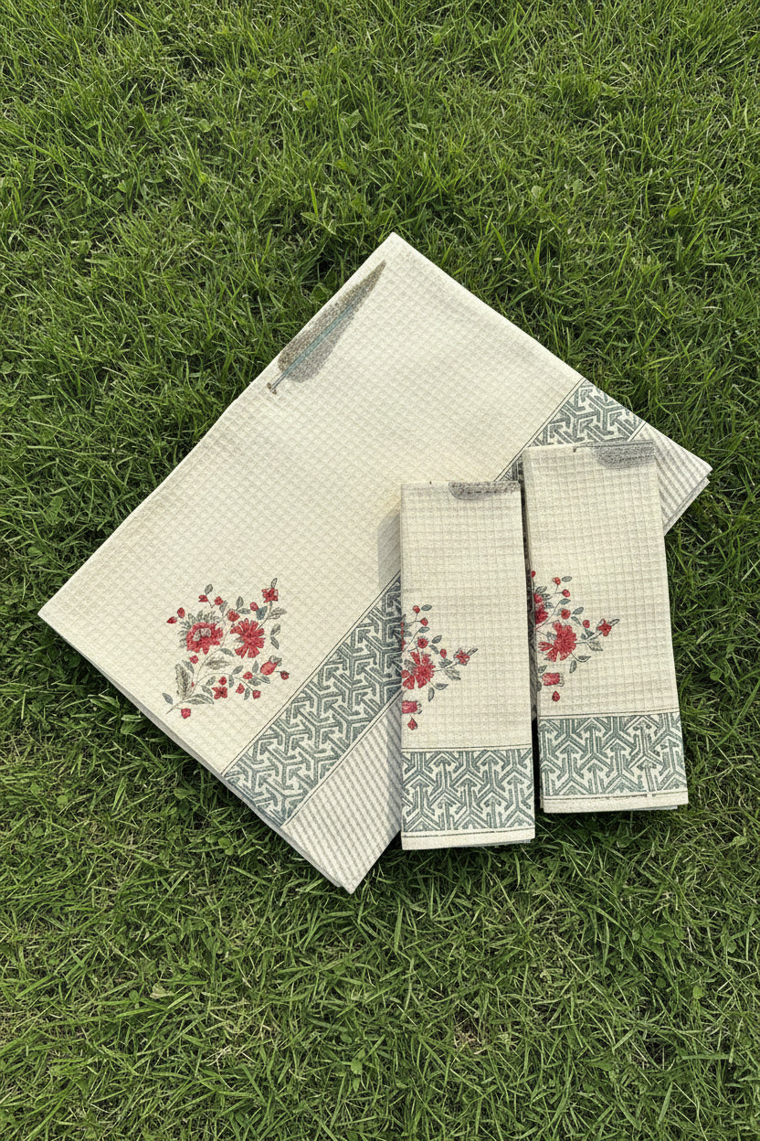 Set of decorative towels with floral patterns on a floral fabric background