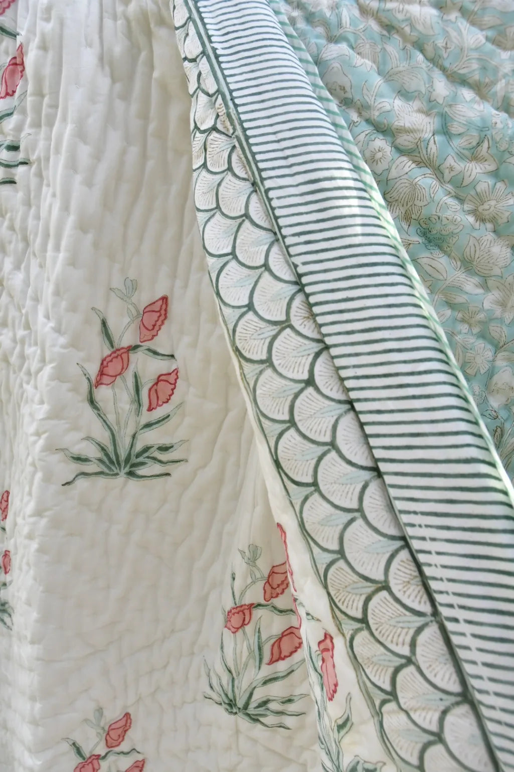 Close-up of a quilt with floral and geometric patterns.