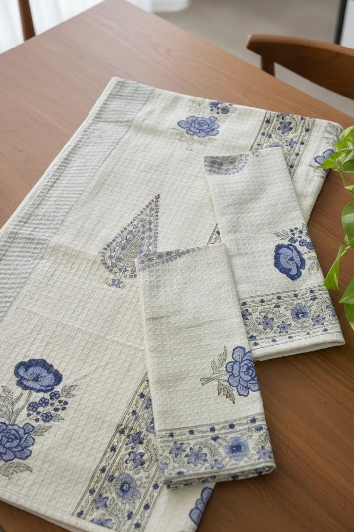 Set of folded towels with blue floral patterns on a wooden table