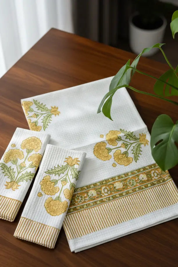 Set of decorative towels with floral patterns on a wooden surface.