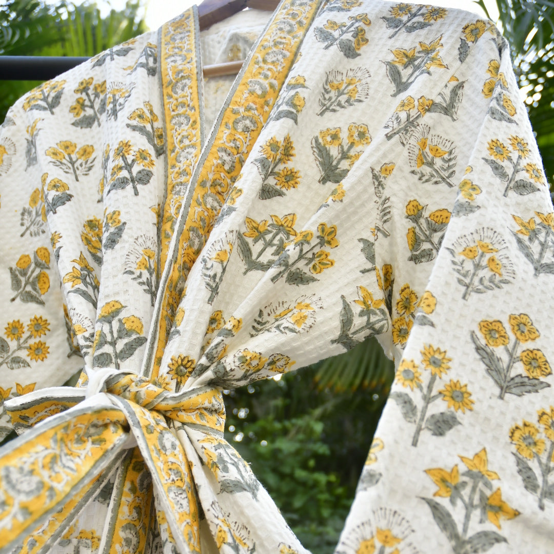 White fabric with yellow and gray floral patterns, possibly a curtain or tablecloth.