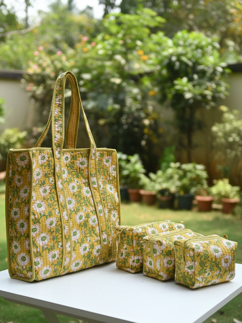 Yellow floral-patterned bag on a bed with a gray wall and wooden headboard in the background.