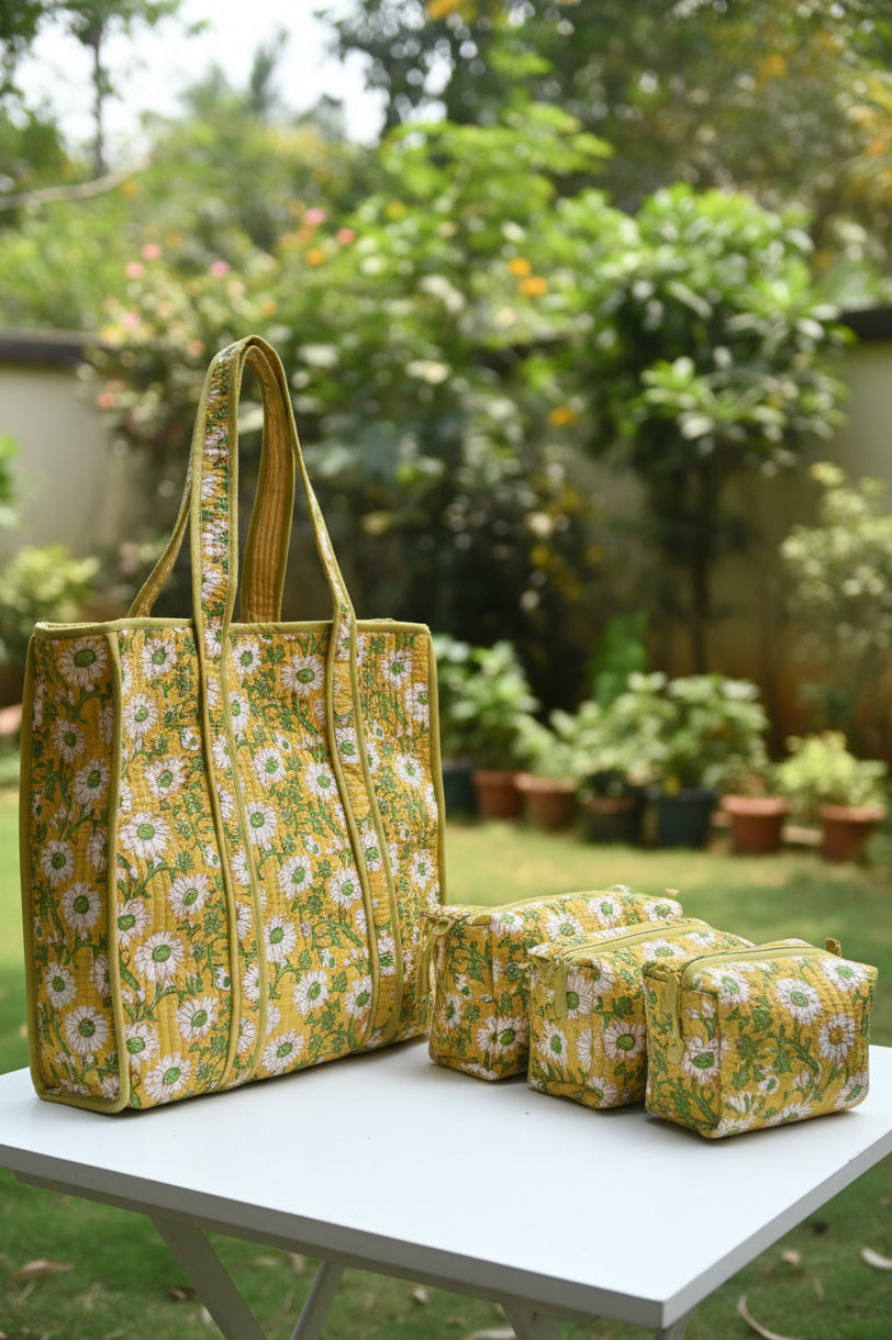 Yellow floral-patterned bag on a bed with a gray wall and wooden headboard in the background.
