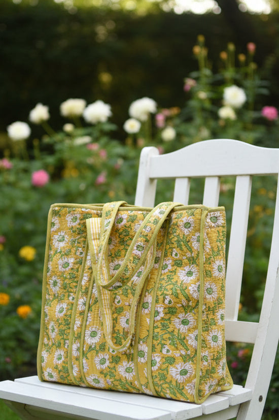 Yellow floral-patterned bag on a gray surface