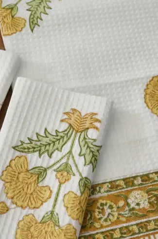 Set of embroidered towels with floral patterns on a wooden surface