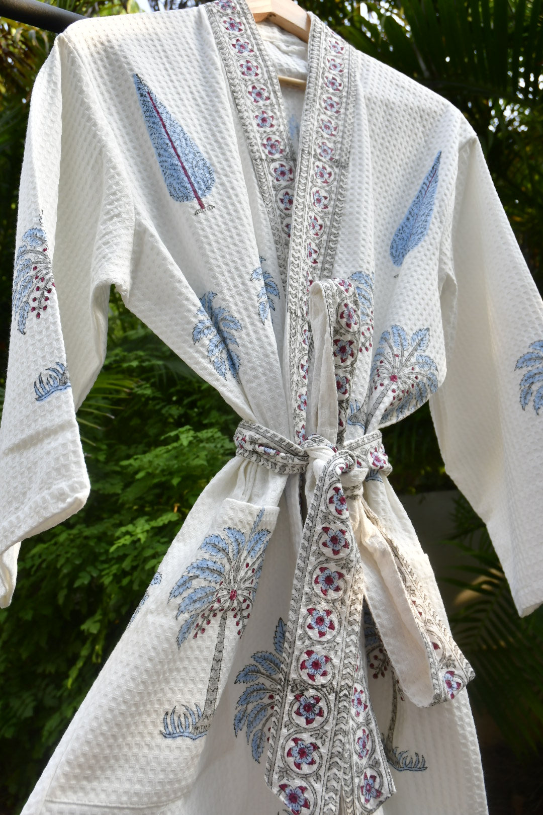 White fabric with floral patterns and a decorative bow on a green background