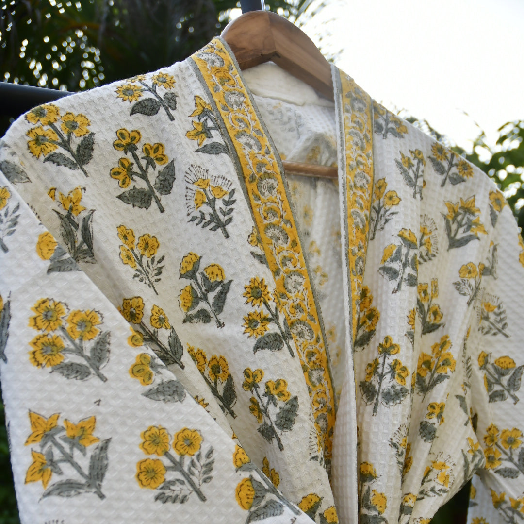 Floral patterned fabric with yellow and gray flowers on a white background