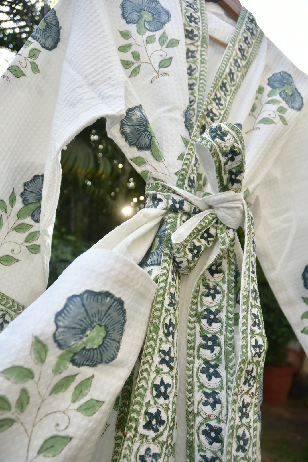 Close-up of a floral-patterned fabric with green and blue designs.