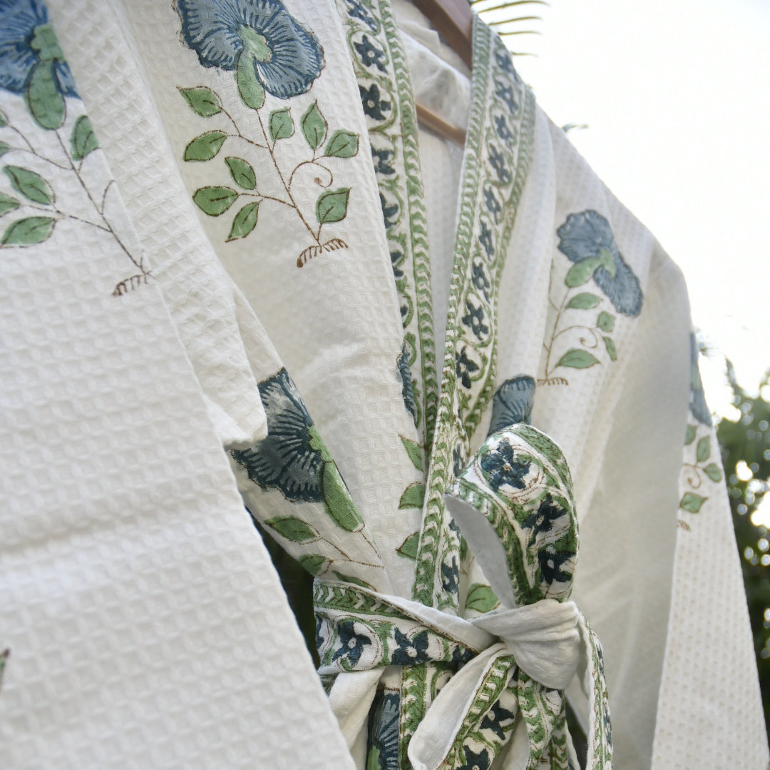 Floral patterned fabric with green and blue designs on a white background