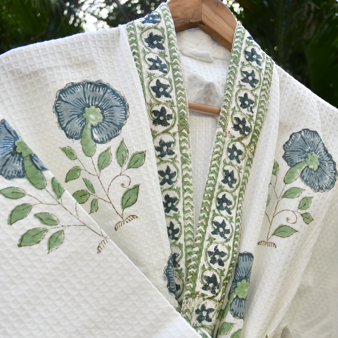 Embroidered fabric with floral and leaf patterns on a white background