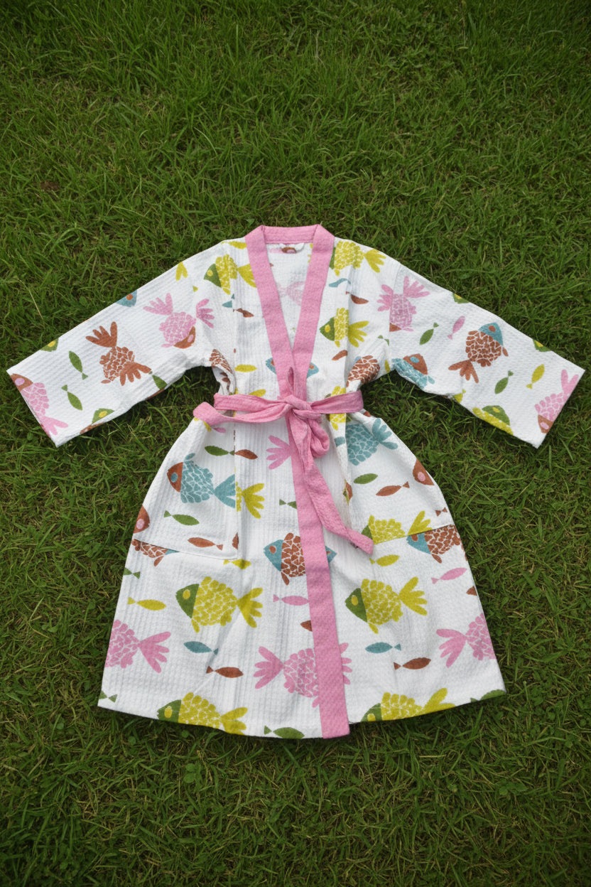 Floral-patterned robe with pink trim on a grassy background