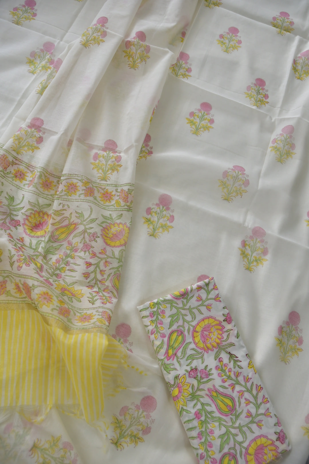 White fabric with colorful floral patterns and yellow accents