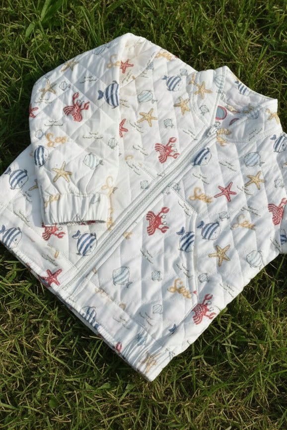 Folded baby quilt with sea creature pattern on a floral background