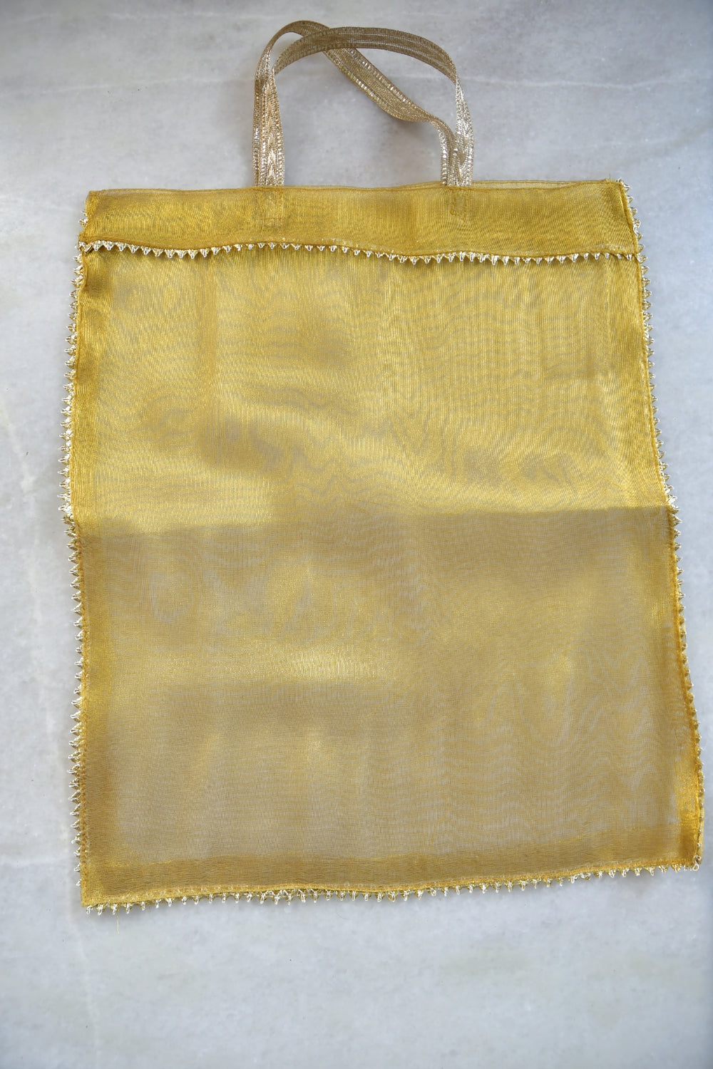 Yellow fabric bag with a handle on a light gray background