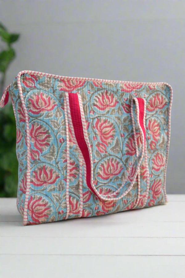 Fabric pouch with floral pattern and pink handles on a light background