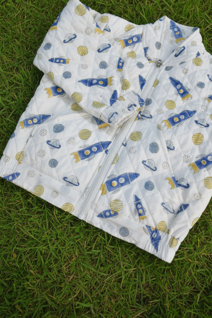 Quilt with rocket ship pattern on a floral background