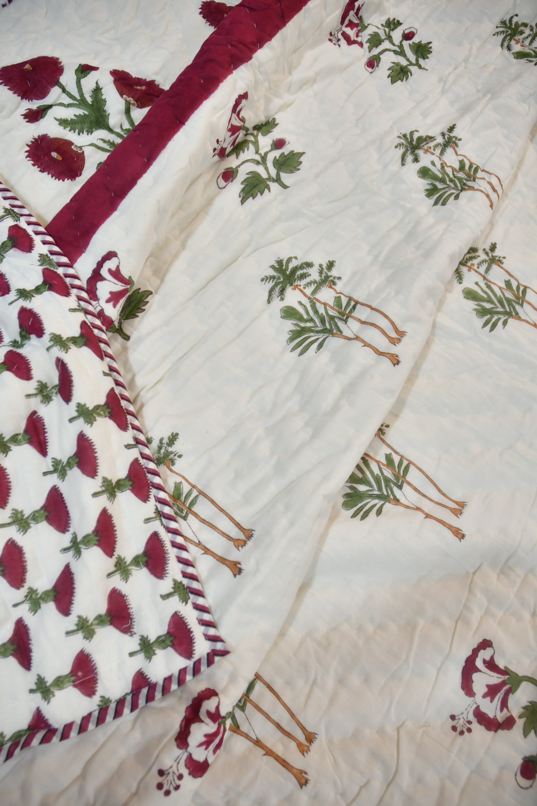 Close-up of a quilt with floral patterns on a white background