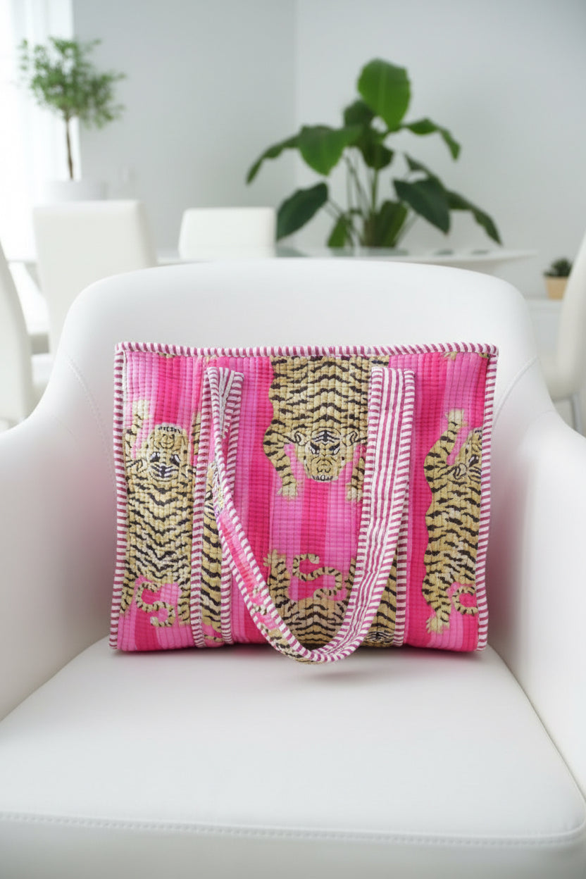 Pink bag with gold tiger design on a white chair