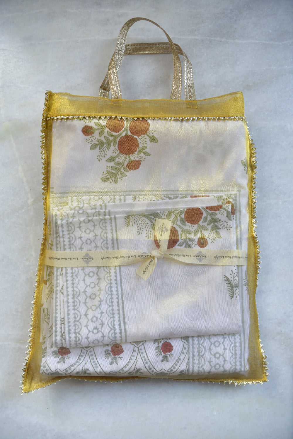 Set of white embroidered napkins with decorative borders and a yellow ribbon on a light gray background.