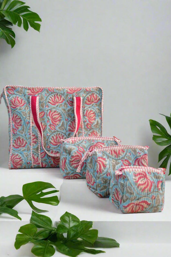 Set of floral-patterned pouches on a white surface with green leaves around