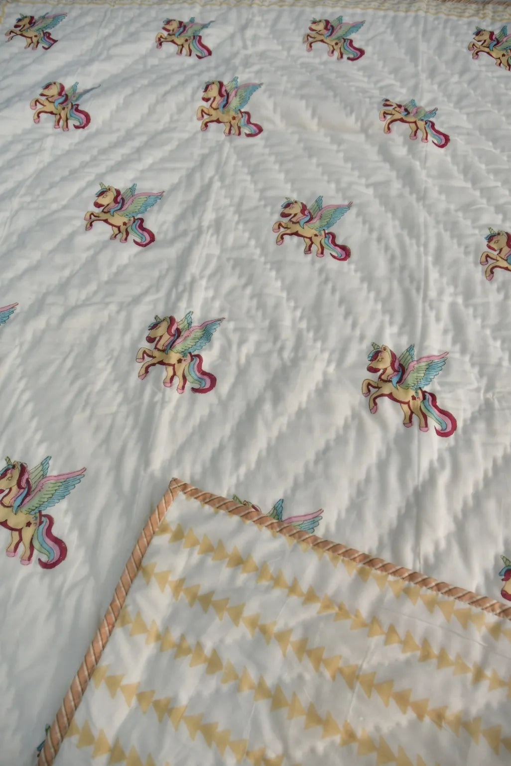 Quilt with embroidered fairy designs on a white background