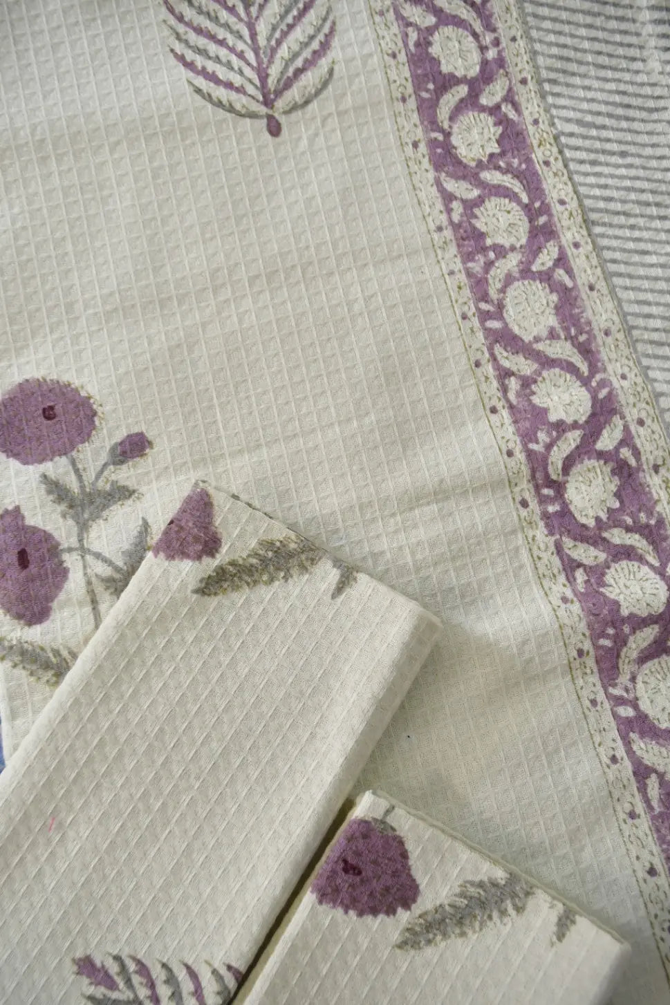 Close-up of a cotton towels with floral patterns and a border on a light background