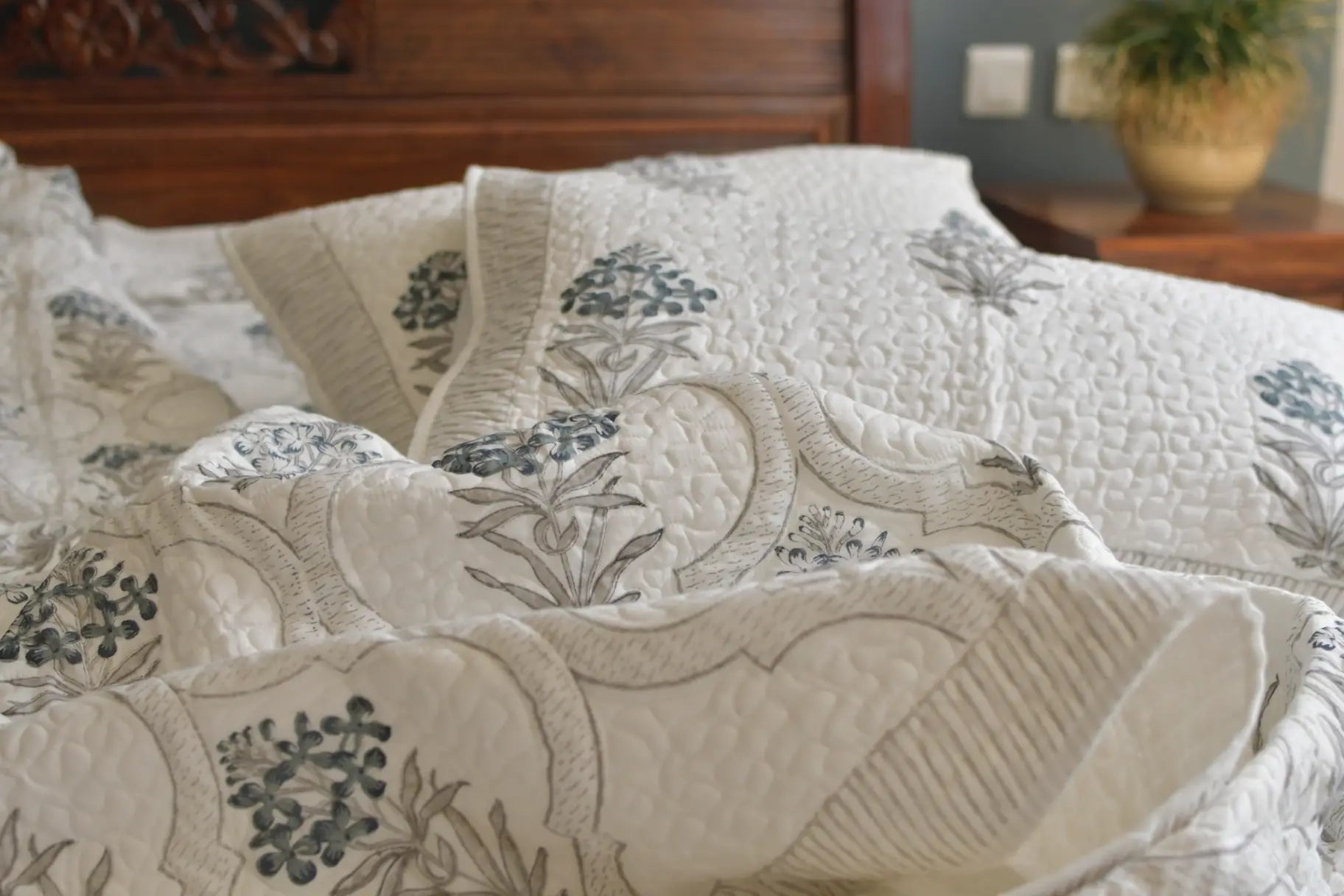 Floral patterned quilt on a bed in a bedroom setting