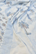 Embroidered palm tree pattern on a light blue and white fabric