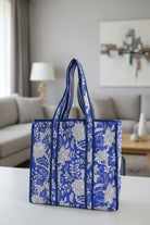 Blue and white floral patterned bag with a plain background