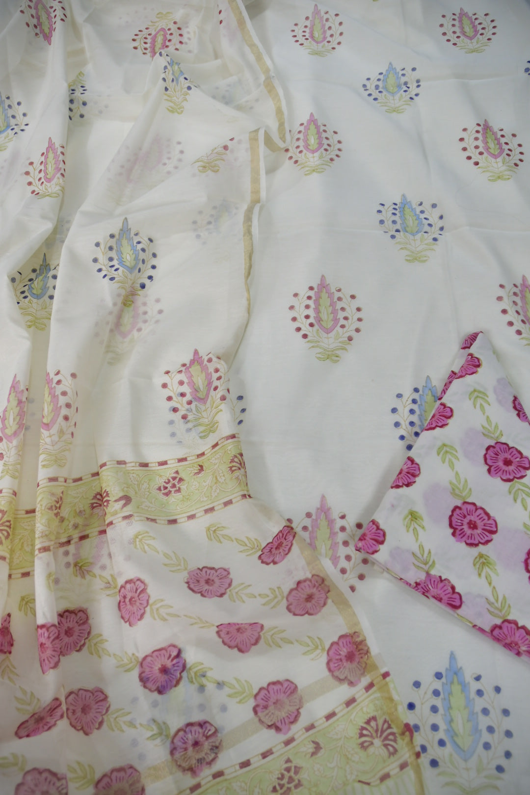 Floral patterned fabric with pink flowers and green leaves on a white background