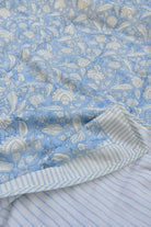 Close-up of blue floral fabric with a striped pattern underneath