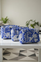 Set of three blue and white floral-patterned pouches on a dark surface with a neutral background