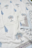 White fabric with blue palm tree patterns and decorative borders