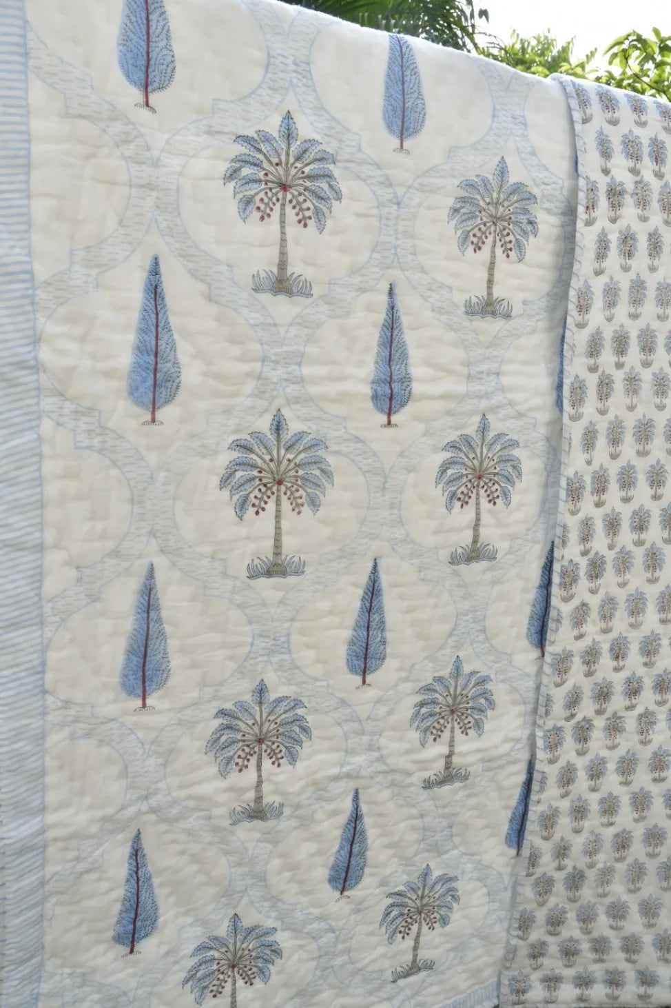 Quilt with tree pattern draped over a surface