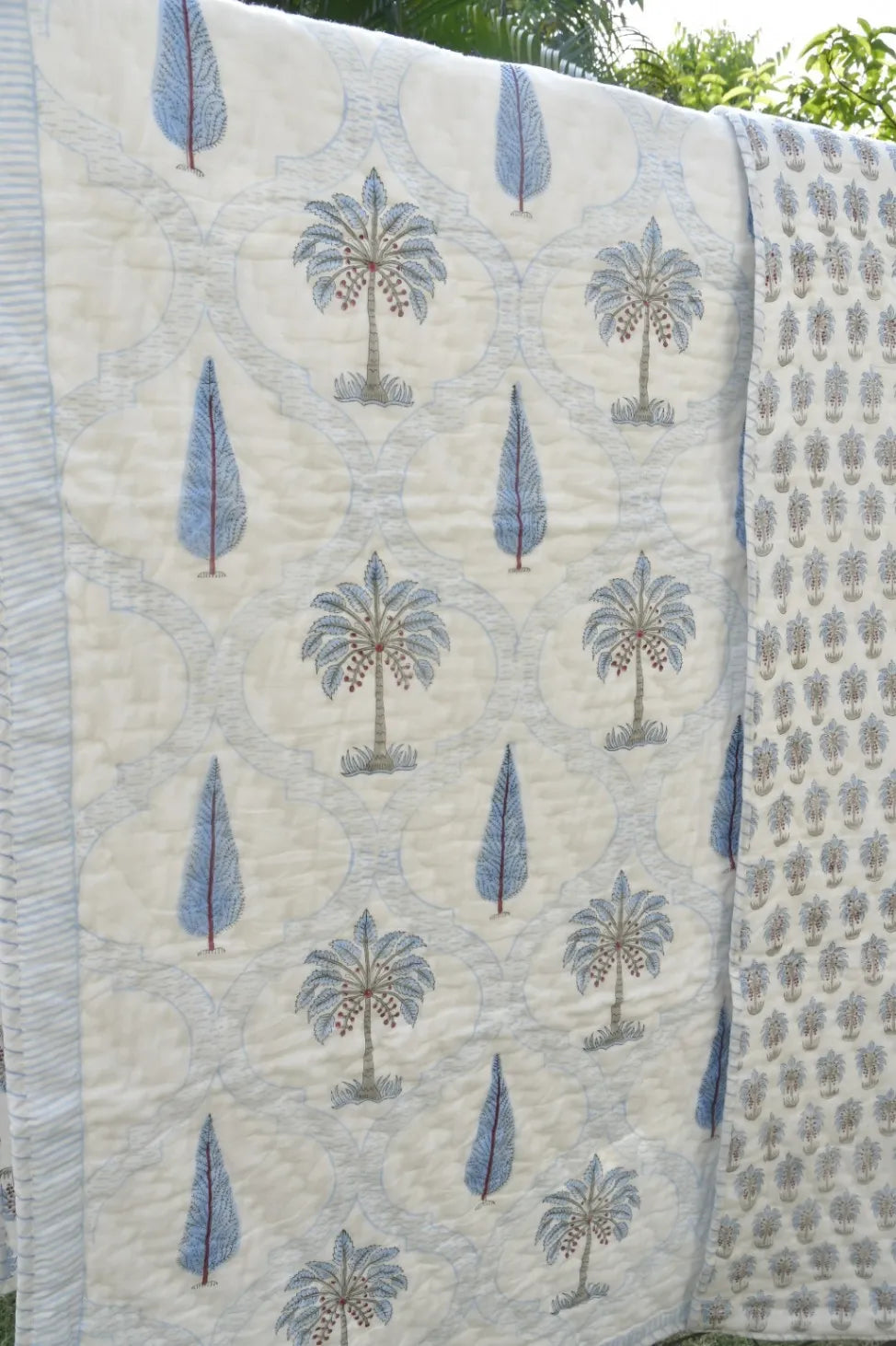 Quilt with palm tree pattern on a white background